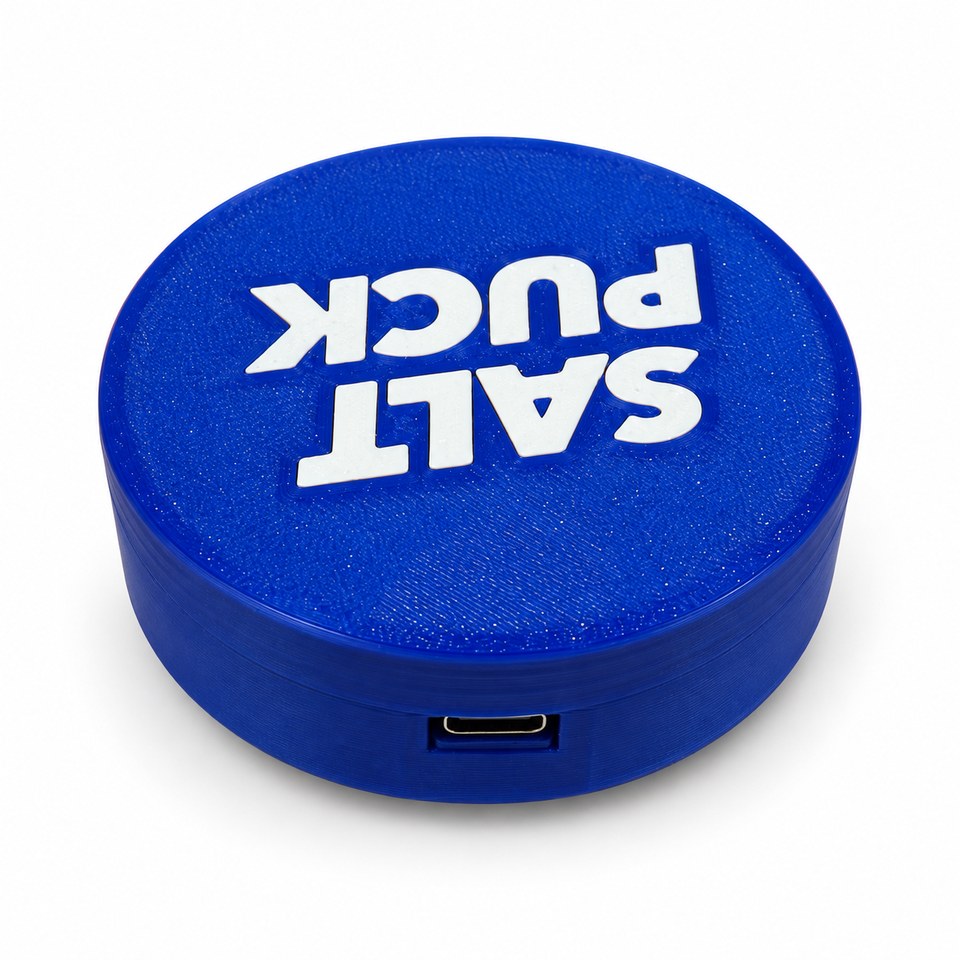 Rear view of the compact cobalt-blue Salt Puck showing the USB-C power connection